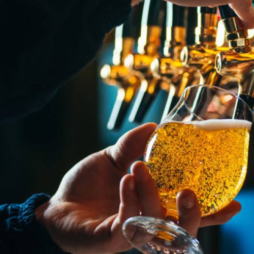 Close up of bartender pouring draft beer in glass